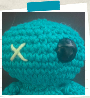 crochet keychain tutorial showing embroidered X for one eye and a safety eye for the other.