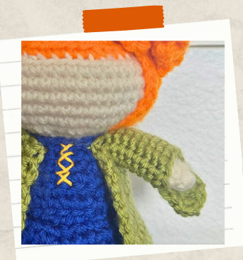 Free witch crochet pattern with curly orange hair and green coat.