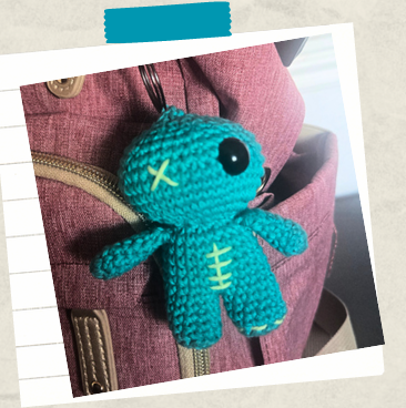 Mini crochet keychain attached to crochet bag showing finished beginner amigurumi project.