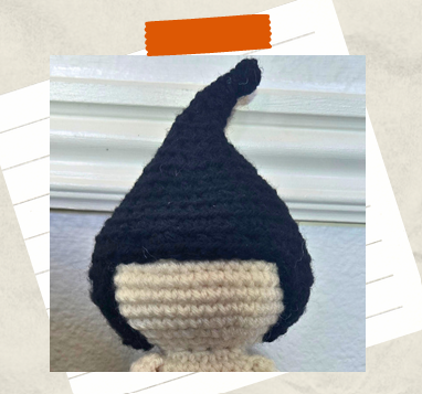 Pointy black crochet witch hair being attached to doll head.