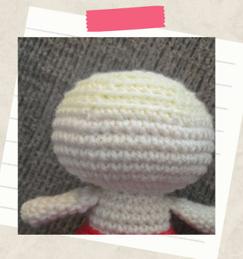 Partially assembled crochet witch doll showing the amigurumi head and body pieces joined together