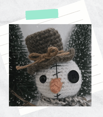 A close up photo showing a completed crochet top hat for an amigurumi snowman.