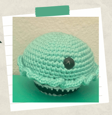 a tutorial picture showing where to place the safety eye on a crochet cupcake