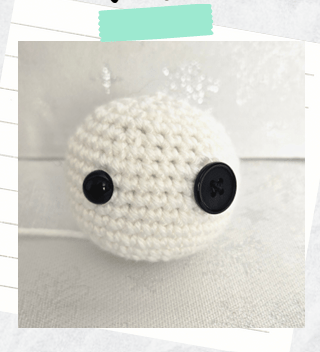 A tutorial photo showing a completed head for a free crochet snowman pattern.