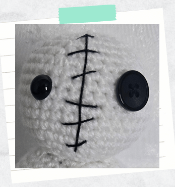 A tutorial photo showing a close up of decorative embroidered stitches for a snowman crochet pattern.