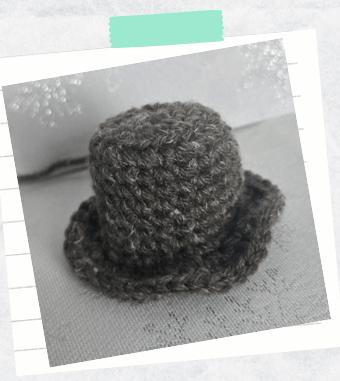 A tutorial photo showing a mini crochet top hat