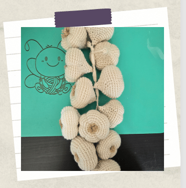 a tutorial picture showing crochet garlic bulbs all fastened together in a braid style
